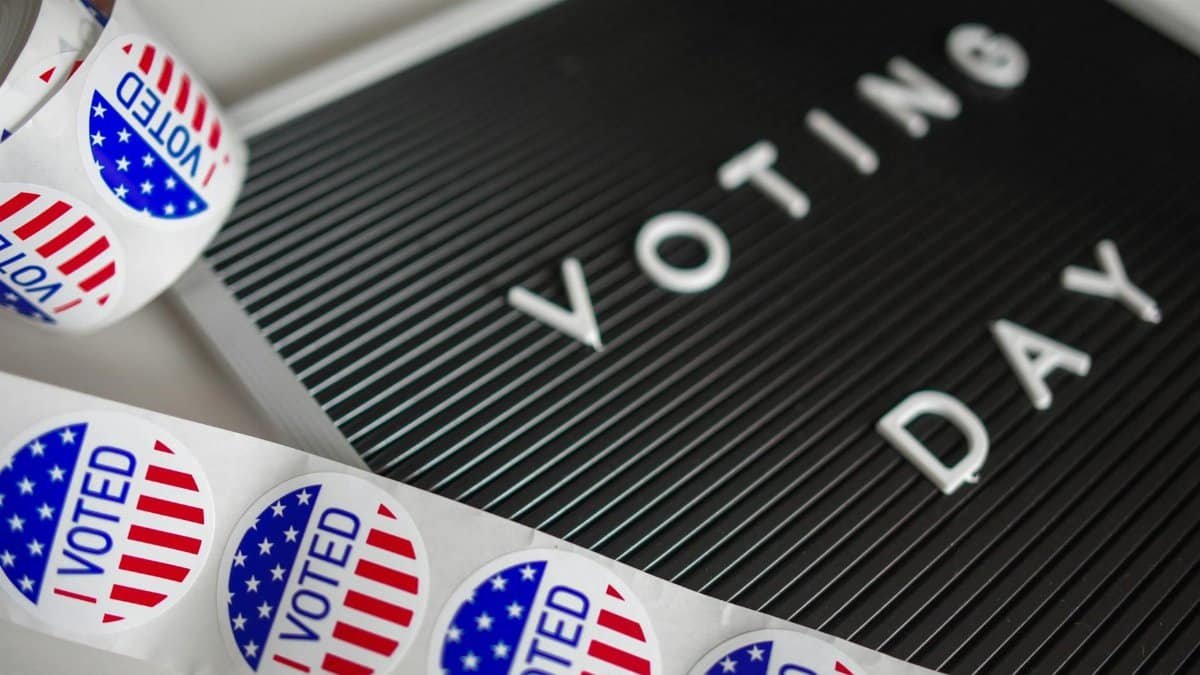 I Voted stickers with an American flag design and Voting Day sign symbolize U.S. electoral participation.
