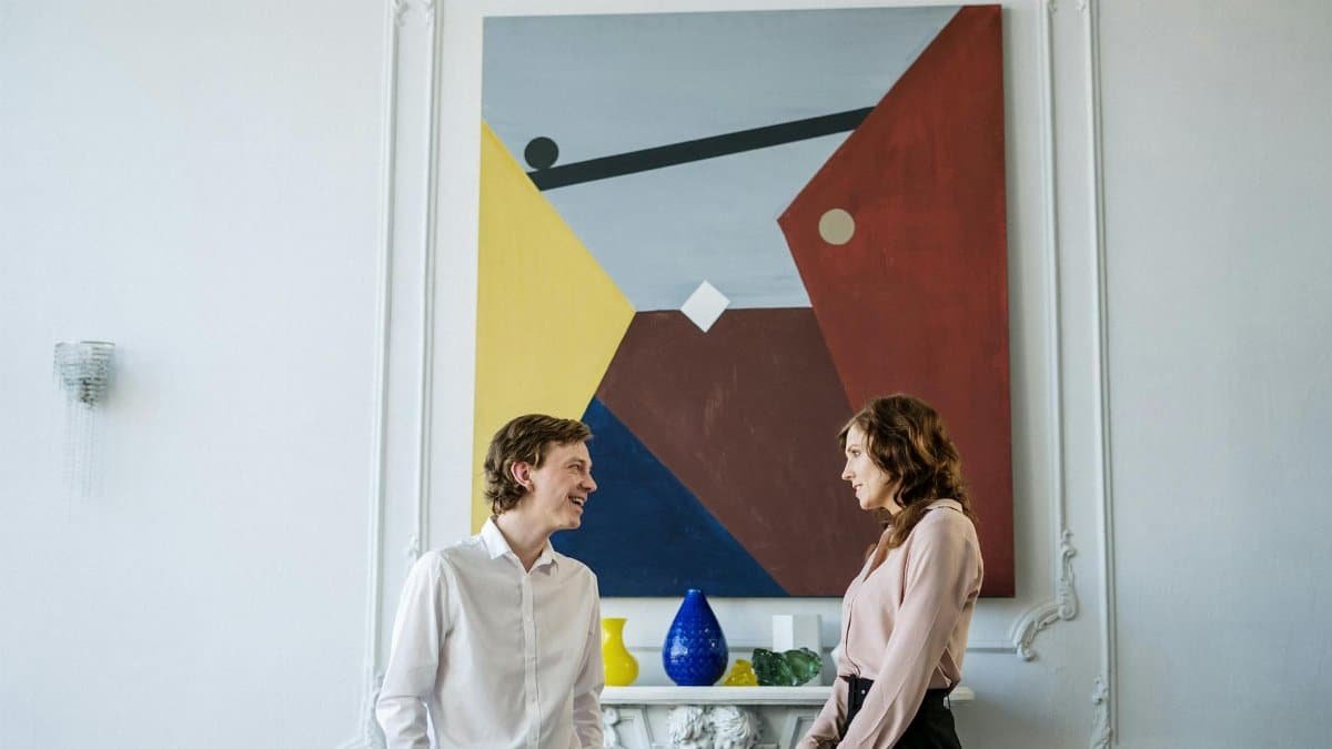 A professional meeting in a stylish office featuring abstract art on the wall.