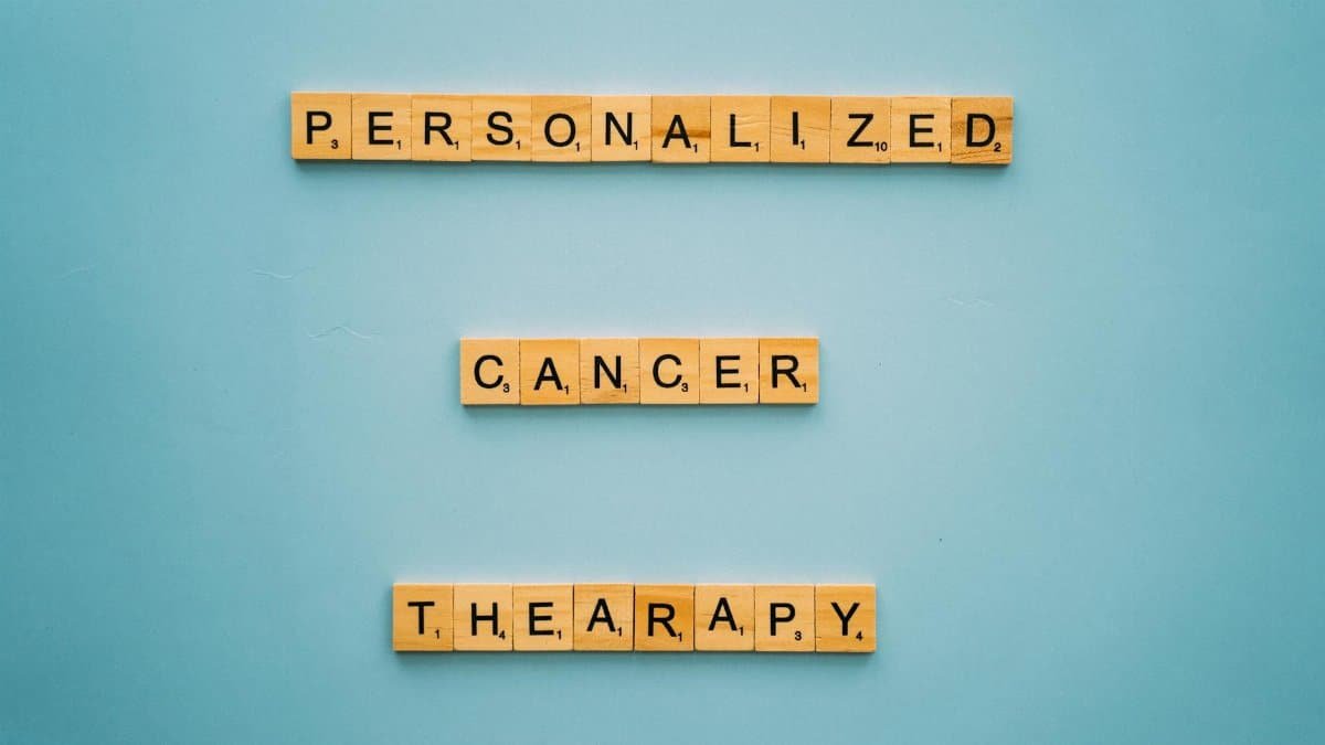 Conceptual image with Scrabble tiles on a blue background spelling 'Personalized Cancer Therapy'.