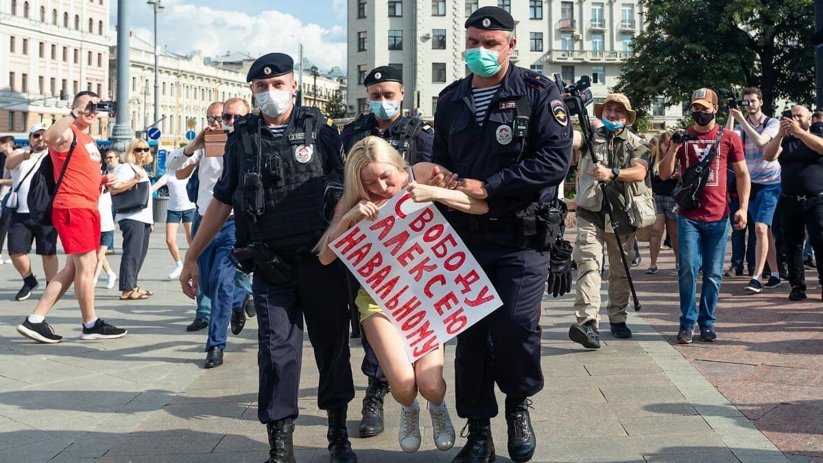Protester being detained by police during an urban demonstration in broad daylight.