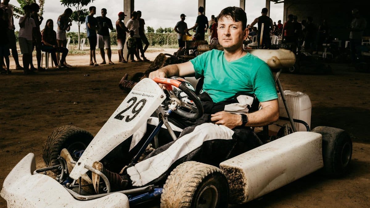 A determined man sits in an off-road kart, preparing for an exciting dirt race.