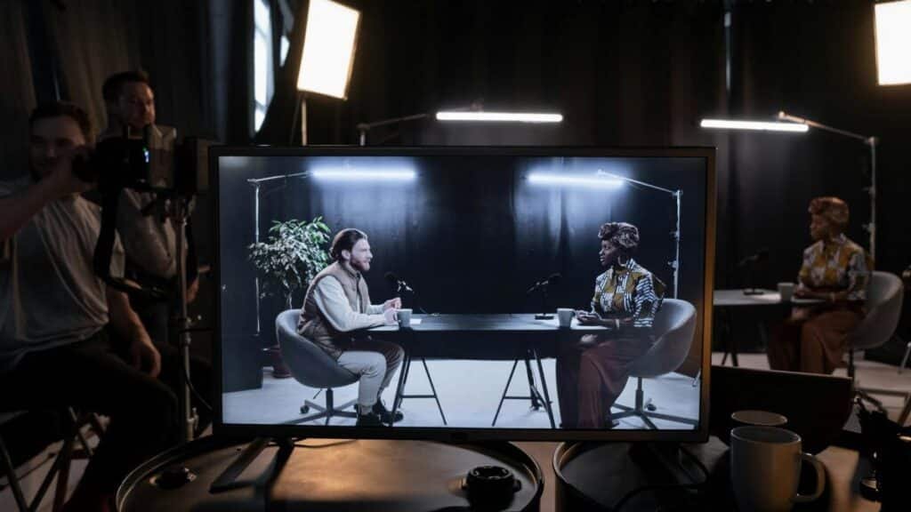 A podcast recording session in a studio with hosts in conversation, captured on screen.