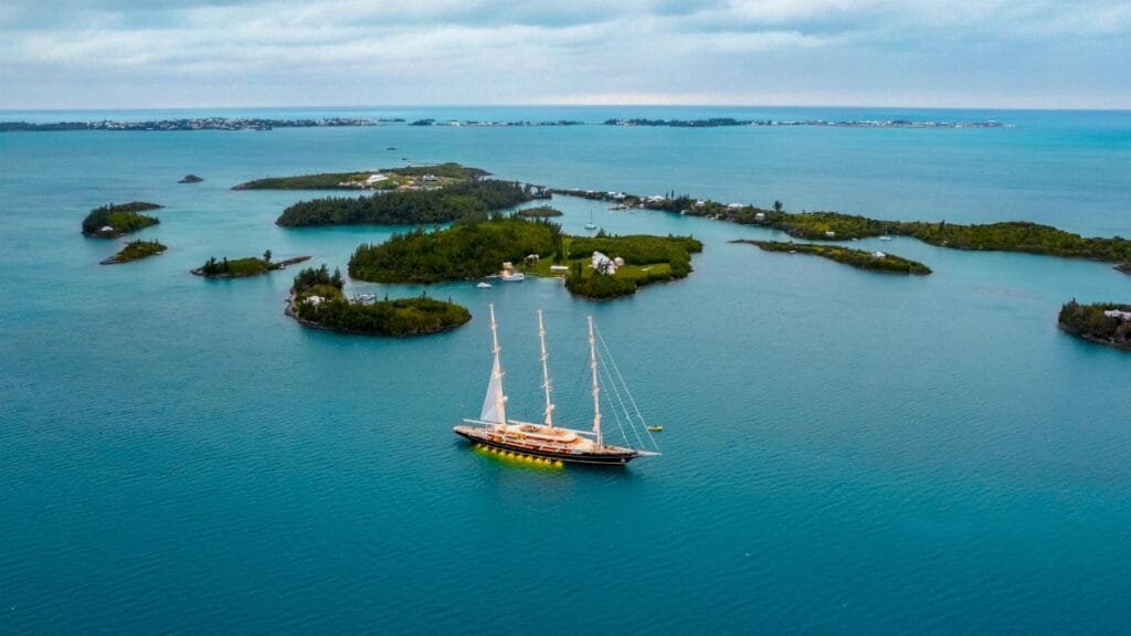 Stunning aerial view of a yacht sailing amidst the scenic islands and azure waters of Bermuda.