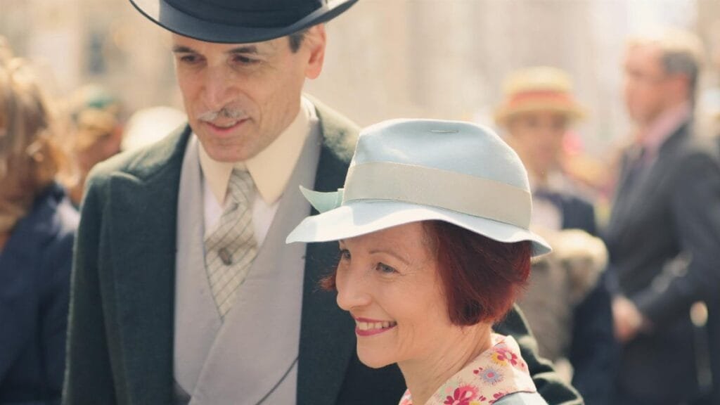 A smiling couple in vintage attire, enjoying a sunny day in New York.