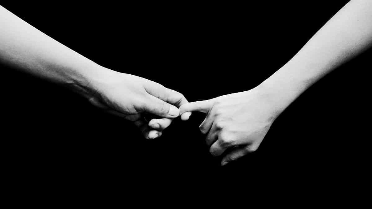Two hands reaching out in a black and white composition, symbolizing connection.