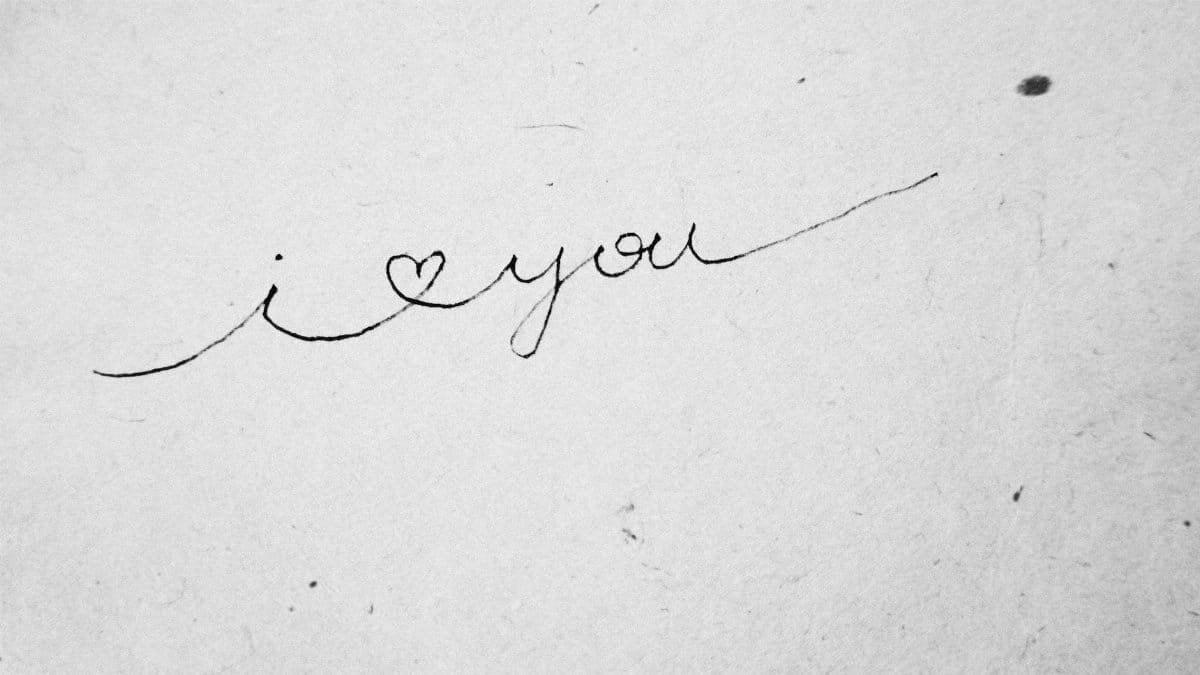 Close-up of 'I love you' handwritten in cursive on textured paper.