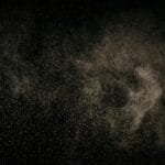 Abstract image of fine particles floating against a black background.