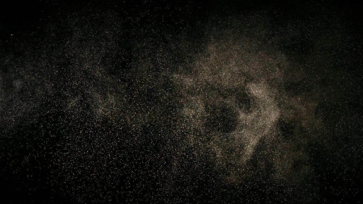 Abstract image of fine particles floating against a black background.