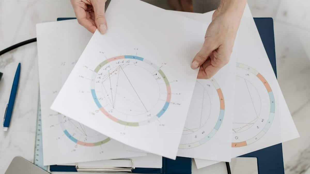 Hands holding astrological charts and graphs, symbolizing horoscopes and fortune-telling.
