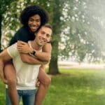 Smiling couple enjoying a playful moment outdoors in a Chicago park.