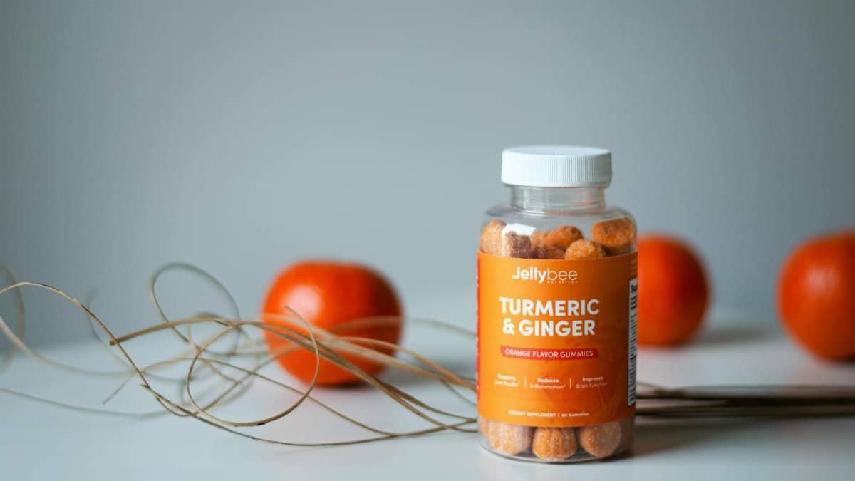 Vibrant still life of turmeric and ginger gummies with fresh oranges.
