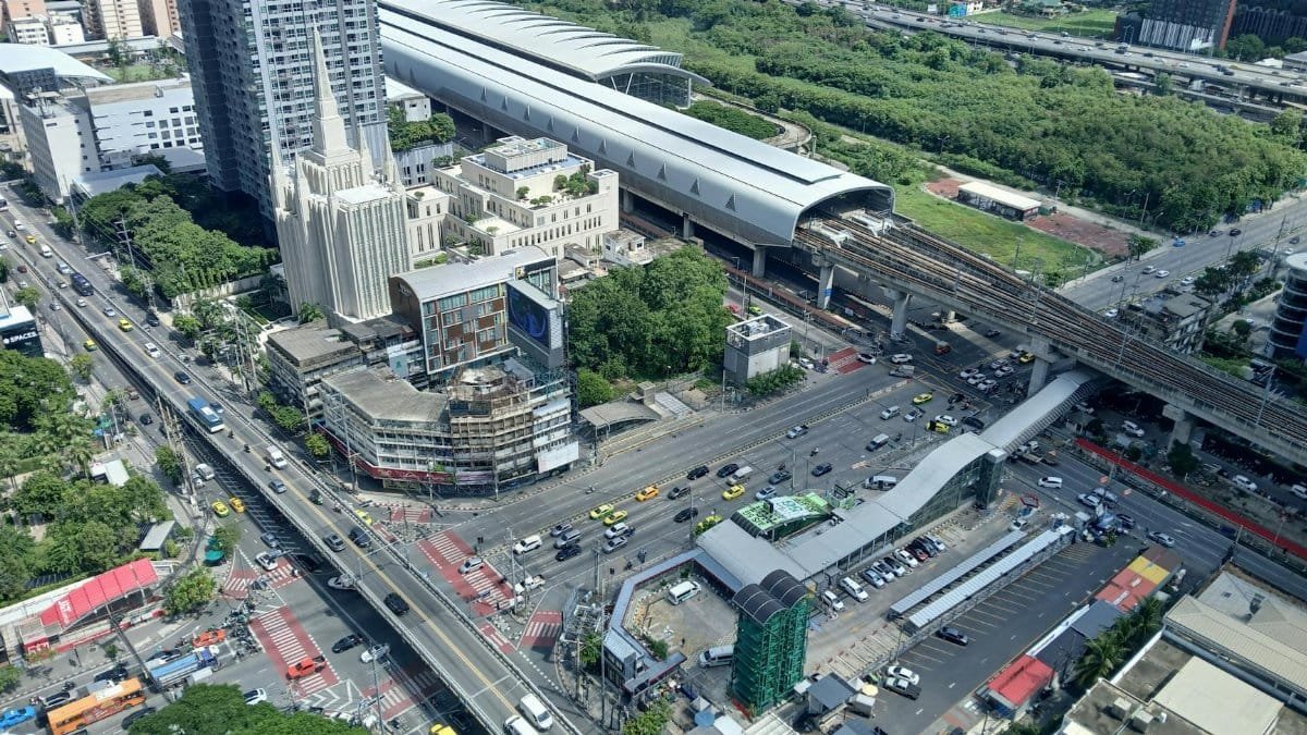 Aerial view of a bustling city intersection and a modern train station with surrounding skyscrapers.