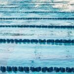 Athletes swimming in Olympic-size pool during a race.