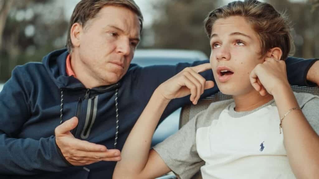 A father and teenage son having an intense conversation, capturing the essence of family dynamics and communication.