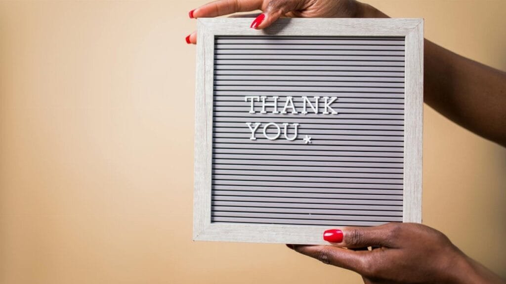 Close-up of hands holding a thank you sign, perfect for expressing gratitude.