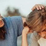 A mother offers support to her discouraged teenager son, portraying love and understanding.