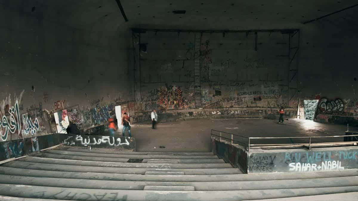 An abandoned gymnasium in Beirut with graffiti art and people. Urban exploration and street art.