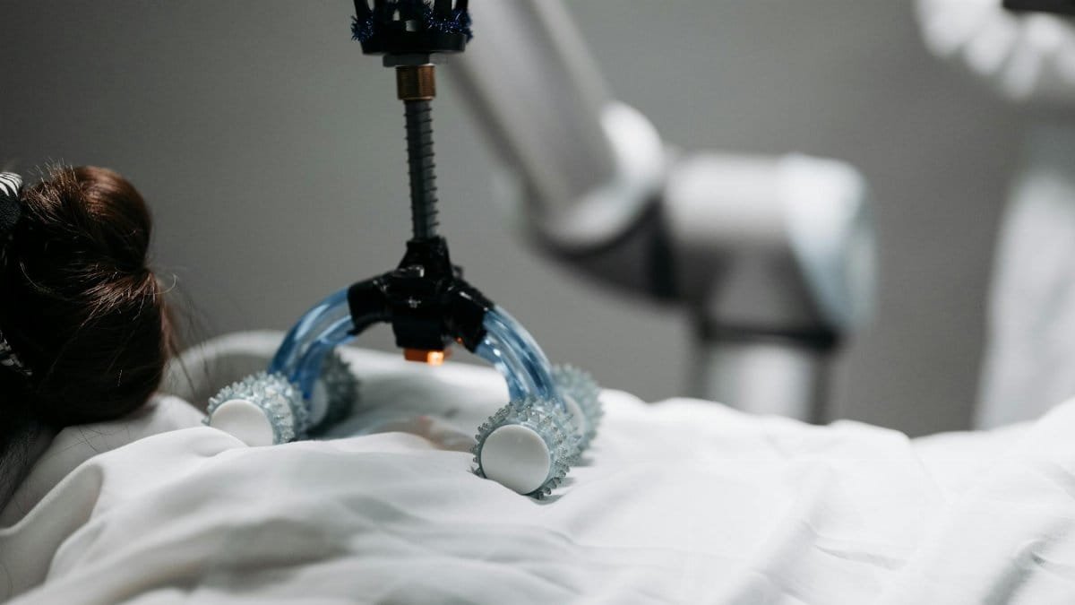 Close-up of a robotic massage arm applying therapy on a person, showcasing innovation.