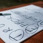 A paper with motivational words and markings placed outdoors on a table.