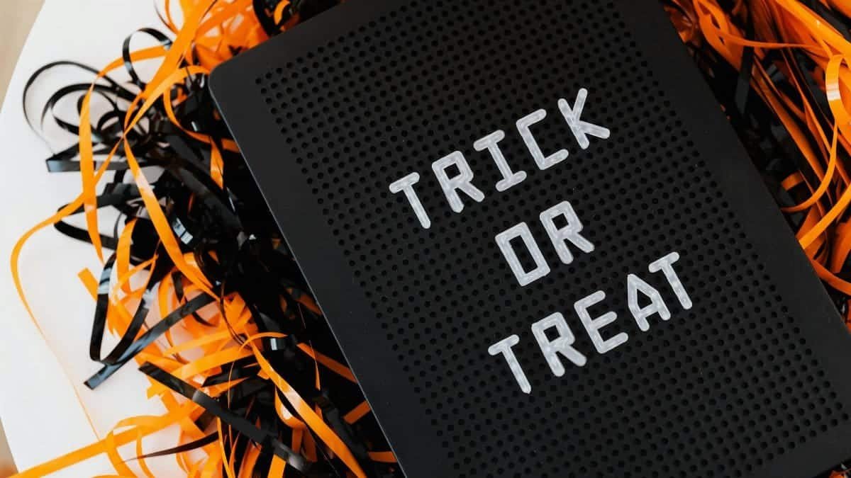 Close-up of a 'Trick or Treat' sign surrounded by festive orange and black streamers, perfect for Halloween decor.