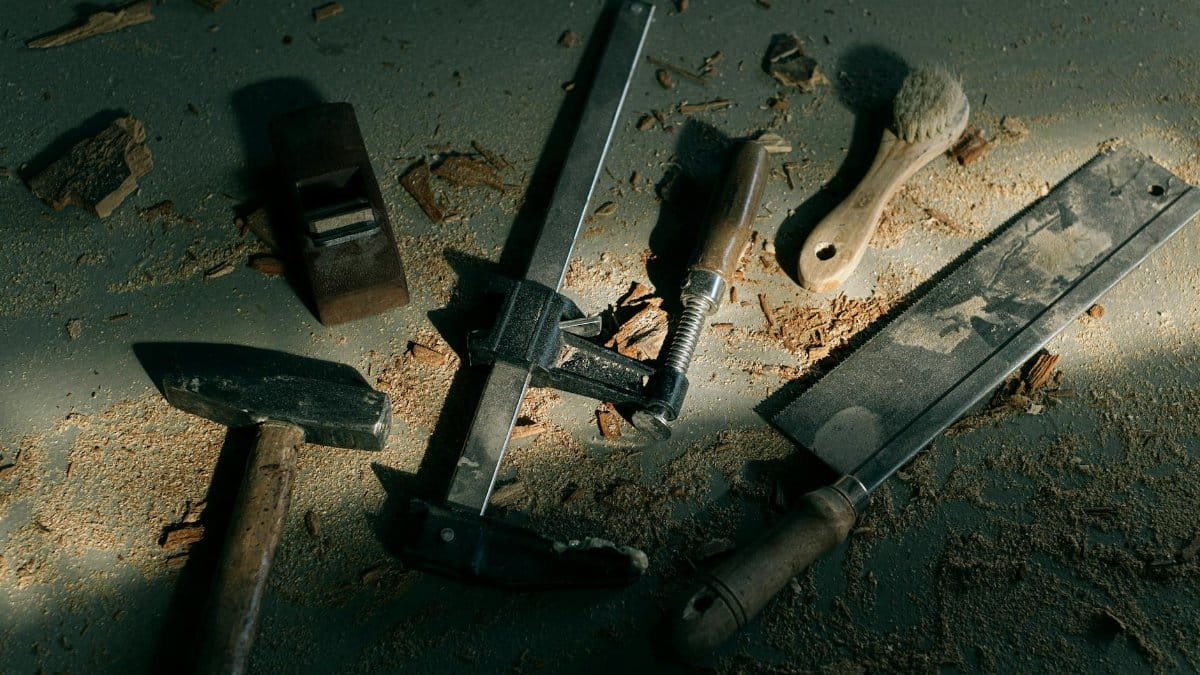 Vintage woodworking tools on a dusty workshop floor, evoking craftsmanship.