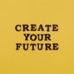 Bold text 'CREATE YOUR FUTURE' on minimalist yellow background. Inspiring design.
