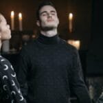 Three individuals engage in a spiritual meditation surrounded by candlelight.
