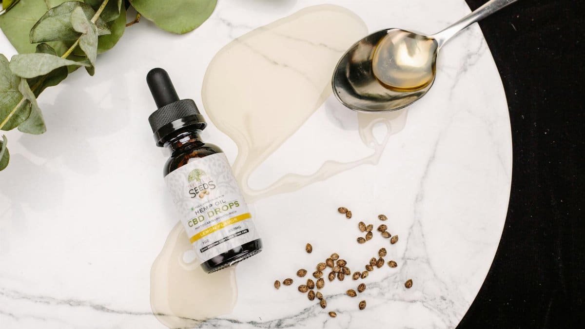 CBD oil drops with seeds and eucalyptus leaves on marble. Perfect for health and wellness themes.