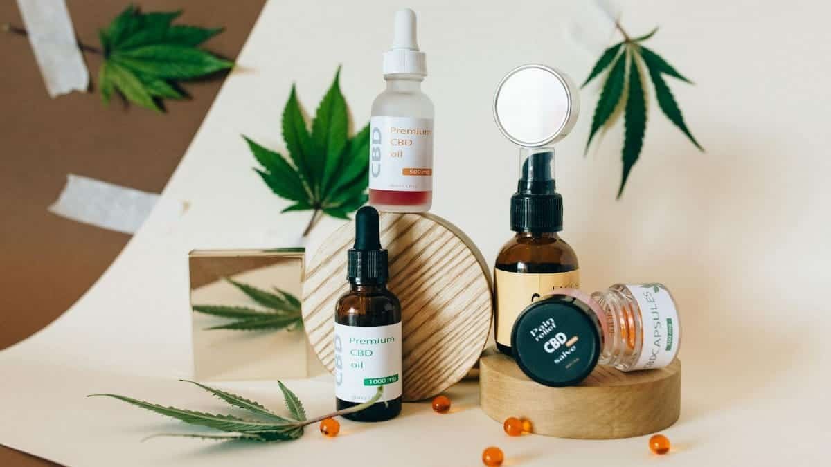 A collection of CBD oil products showcased with cannabis leaves on a neutral background.