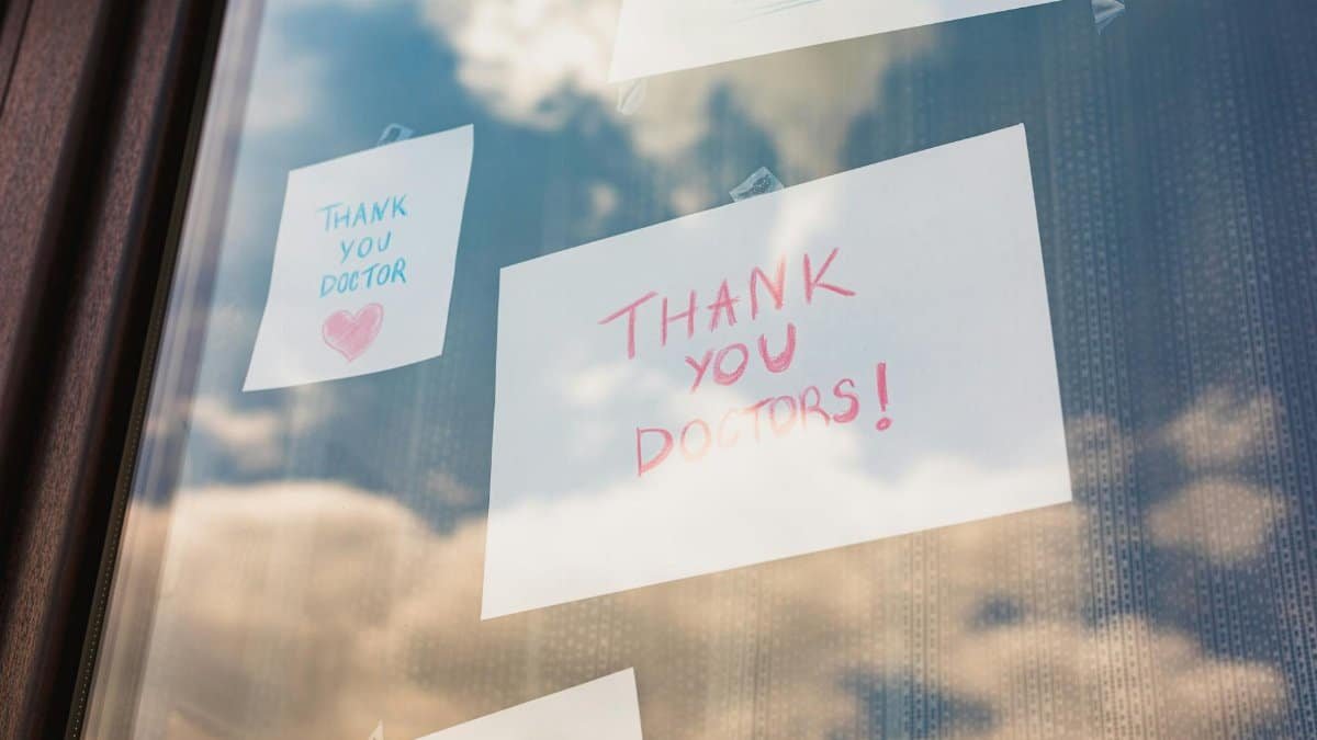 Handwritten thank you notes to doctors taped on a window, reflecting gratitude in challenging times.