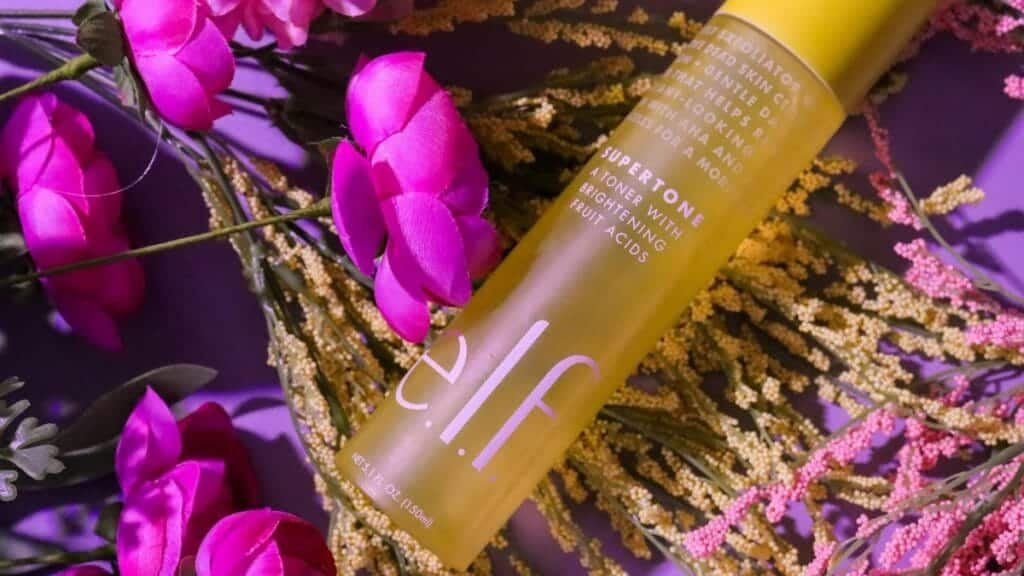 Vibrant skincare bottle with pink flowers and foliage, creating a fresh look.