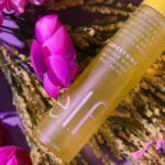 Vibrant skincare bottle with pink flowers and foliage, creating a fresh look.