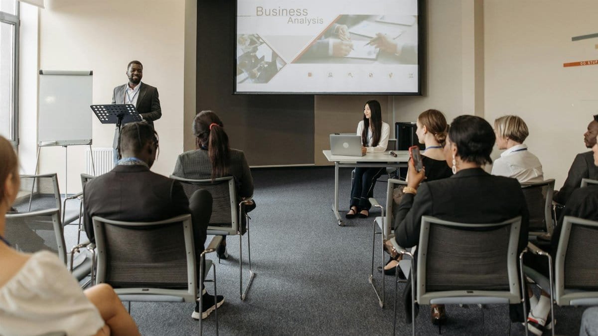 A diverse group of adults attending a presentation in a conference room setting.