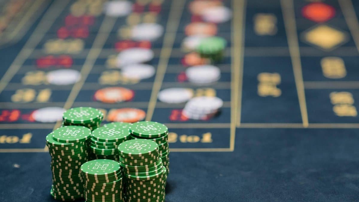 Stack of green poker chips on a casino table, highlighting the gambling theme.