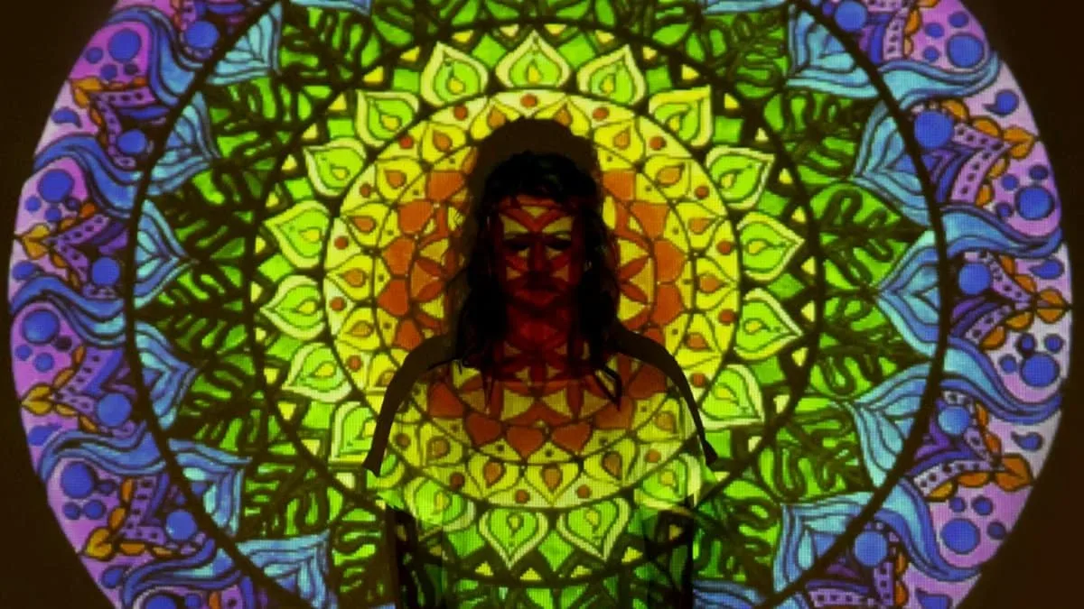 Colorful mandala projection on a silhouette, blending intricate patterns and vibrant hues.