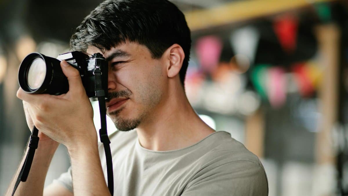 Focused photographer using a DSLR camera, capturing candid moments indoors.
