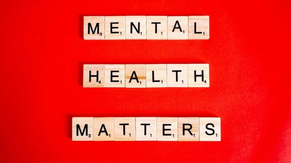 Wooden tiles spelling 'Mental Health Matters' on a vivid red background.
