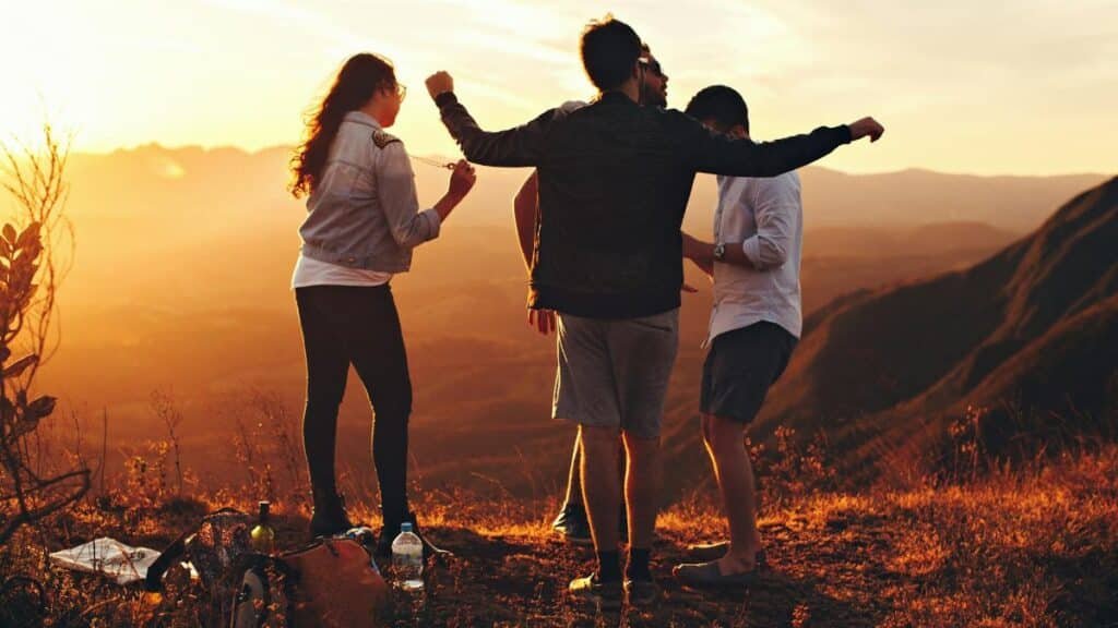 Joyful group of young adults enjoying a sunset view in a mountainous landscape in Brazil.