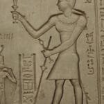 Close-up of detailed hieroglyphs and carvings on an ancient Egyptian temple wall, depicting historical symbols.