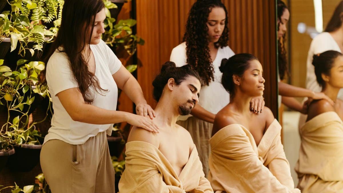 Two clients enjoy a relaxing massage from professional therapists in a spa setting, promoting wellness and relaxation.