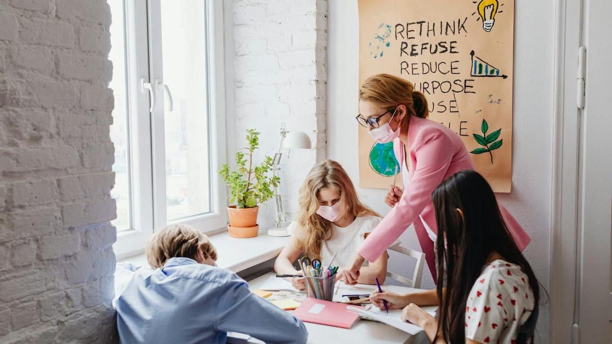A teacher guides students in a classroom project focused on zero waste education, promoting sustainability.