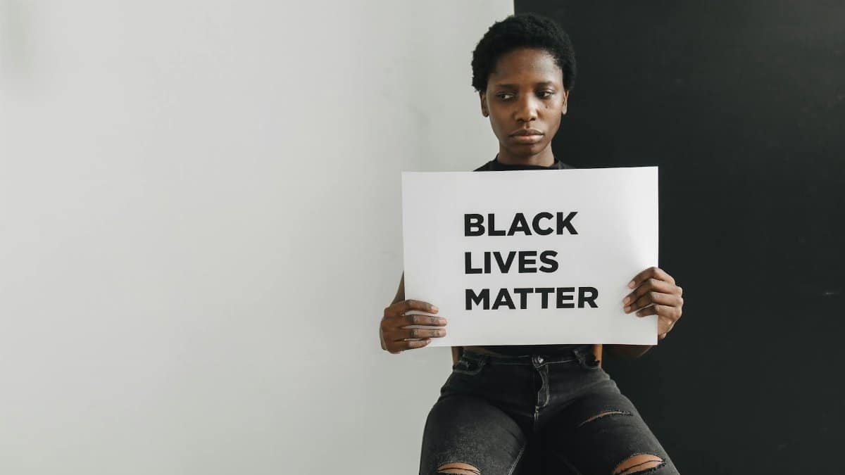 A person holding a Black Lives Matter sign emphasizing racial equality and justice.