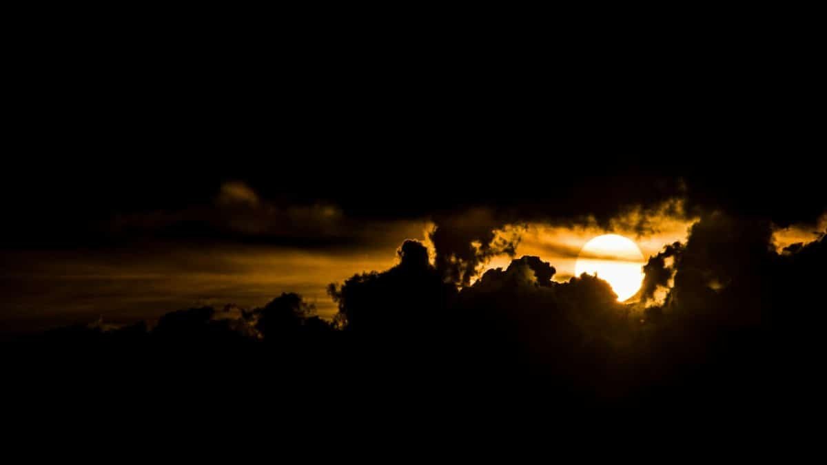 Captivating sunset with bold colors and silhouetted clouds creating a dramatic sky scene.