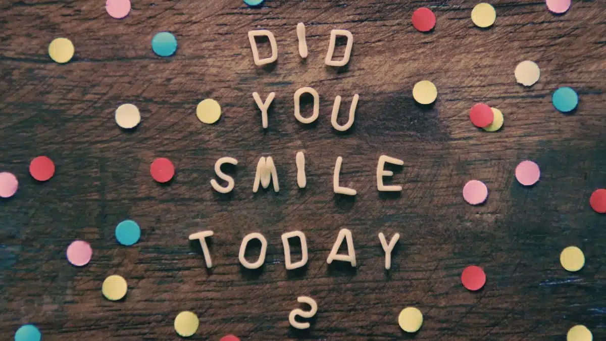Bright confetti and inspiring text on wooden background with a question: Did you smile today?