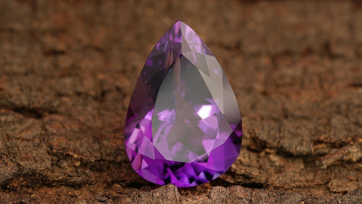 Detailed shot of a polished amethyst gemstone showcasing its vibrant purple hue and clarity.