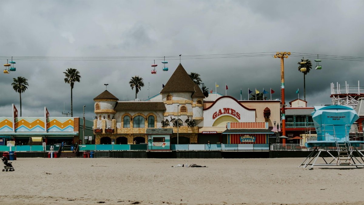 Vibrant Santa Cruz Beach Boardwalk with rides and cloudy sky.