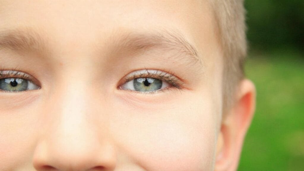 A close-up portrait of a young boy focusing on his blue eyes.