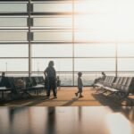 Silhouettes of travelers in a sunlit airport terminal in Shanghai, China.