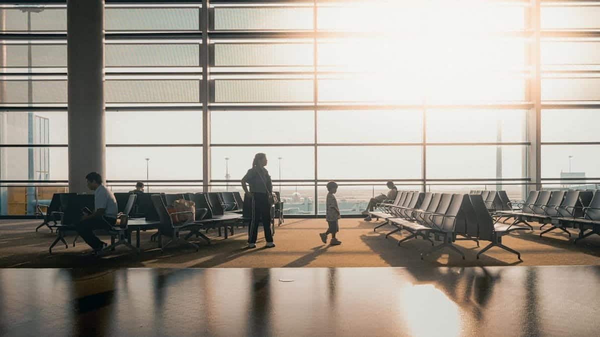 Silhouettes of travelers in a sunlit airport terminal in Shanghai, China.