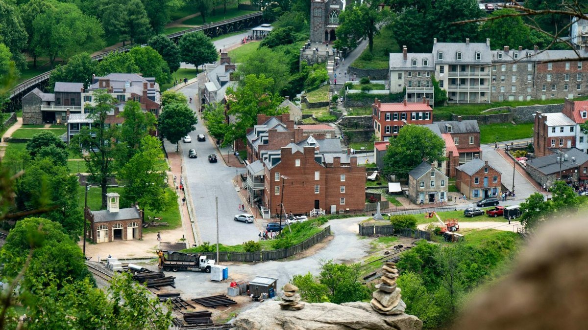Aerial view of Harpers Ferry, showcasing historic buildings surrounded by lush greenery.